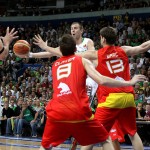 Tomas Delininkaitis passes the ball while being guarded by two Spanairds. Photo by Ray Vyšniauskas.