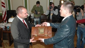 Latvian finance minister Einars Repše (right) hands the government's draft of the national budget to Speaker of the Saeima Gundars Daudze (left) Friday. Photo used courtesy of the Saeima Chancellery.