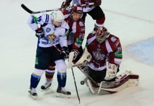 Dinamo Riga's Oļegs Sorokins (28) does his best to get between MVD's Denis Kokarev (19) and Dinamo Riga goalie Edgars Masaļskis (31) to clear the puck from the goal area. 