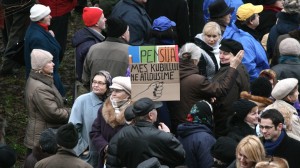 A Lithuanian pensioner holds up an anti-Kubilius sign, which translates to "For the pension, we give Kubilius this," with an image of a clenched fist. Tuesday and Thursday saw large protests against the proposed budget cuts held outside the Seimas building. Photo by Nathan Greenhalgh.