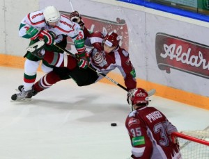 An unidentified Dinamo Riga player does all he can to get between the opposition and the puck as goalie Martin Prusek looks on. Photo used courtesy of Dinamo Riga.