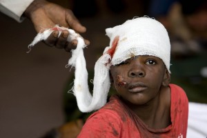 A Haitian boy receives treatment at an ad hoc medical clinic in Port-au-Prince. The situation on the ground in Haiti remains chaotic, and many more may die from untreated injuries than from the earthquake itself.