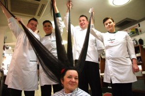 Barber's hold up Violeta Salaseviciene's hair 1.5 meter-long hair before getting out the scissors. The removed hair is now for sale on eBay.