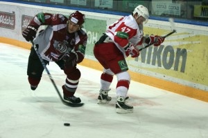 Dinamo Riga's Sandis Ozoliņš (8) strips the puck from Vityaz's Anton Nosov. Dinamo Riga's defense kept the opponent's score at goose egg. Photo by Nathan Greenhalgh.