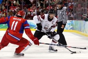 Latvian hockey player Kārlis Skrastiņš tries to manuever past Russian Evgeni Malkin. Latvia eventually went down 2-8 against Russia.